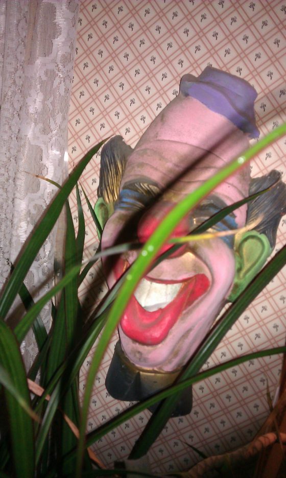 Behind a large floor plant in the bathroom was hidden a creepy clown. A giant creepy clown. WHY?!